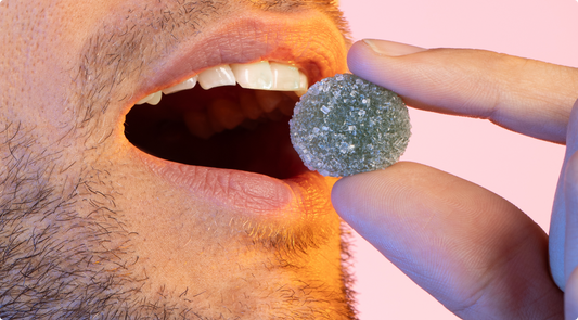Close-up of a person holding a sugar-coated kratom gummy near their open mouth